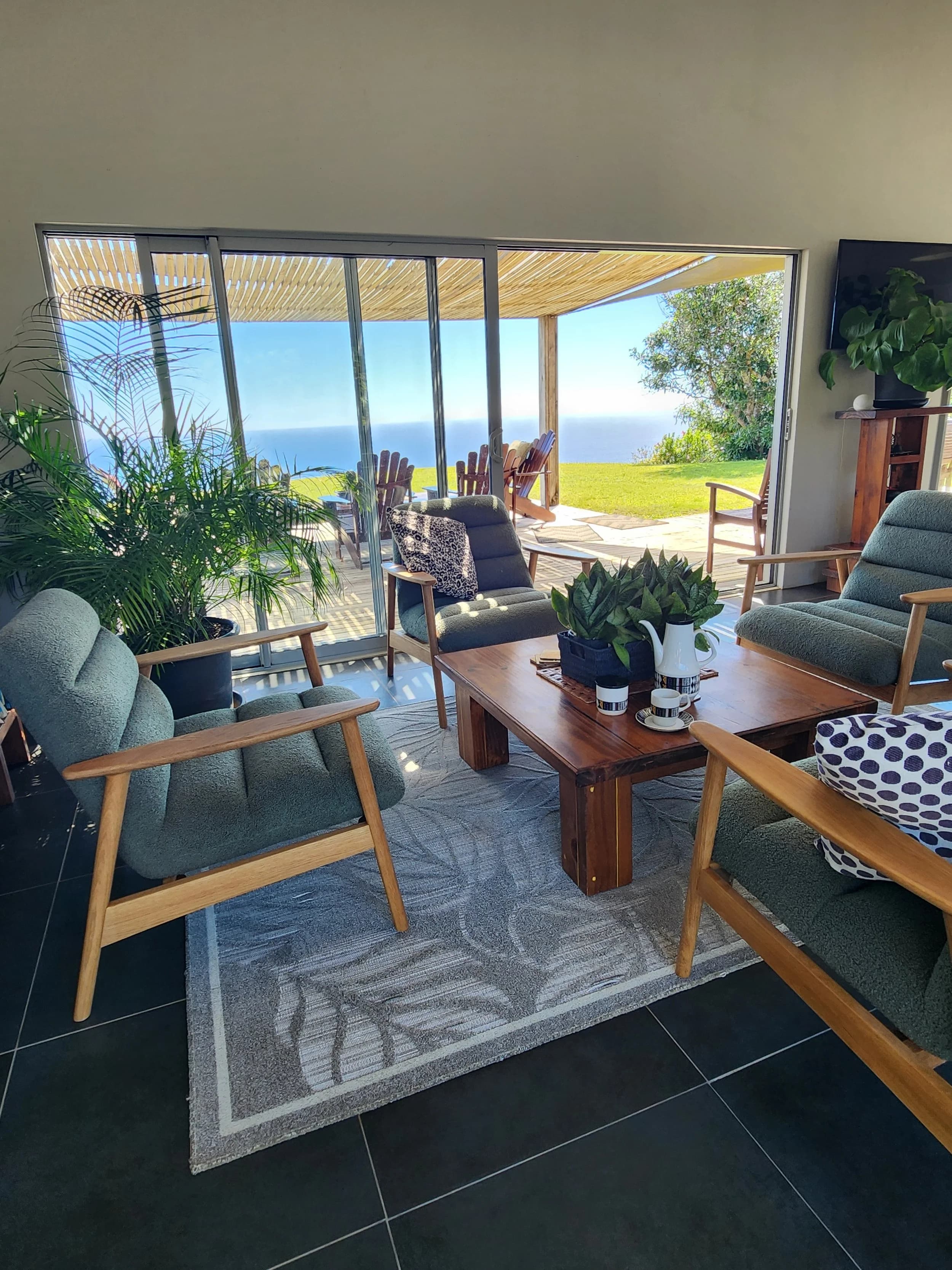 Big Flower's lounge, opening through wide glass doors to the deck, garden and ocean