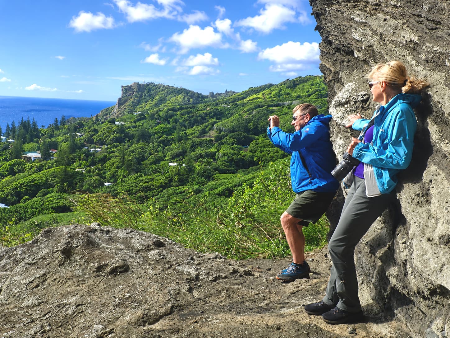 Two walkers at Christian's Cave, looking out over the island