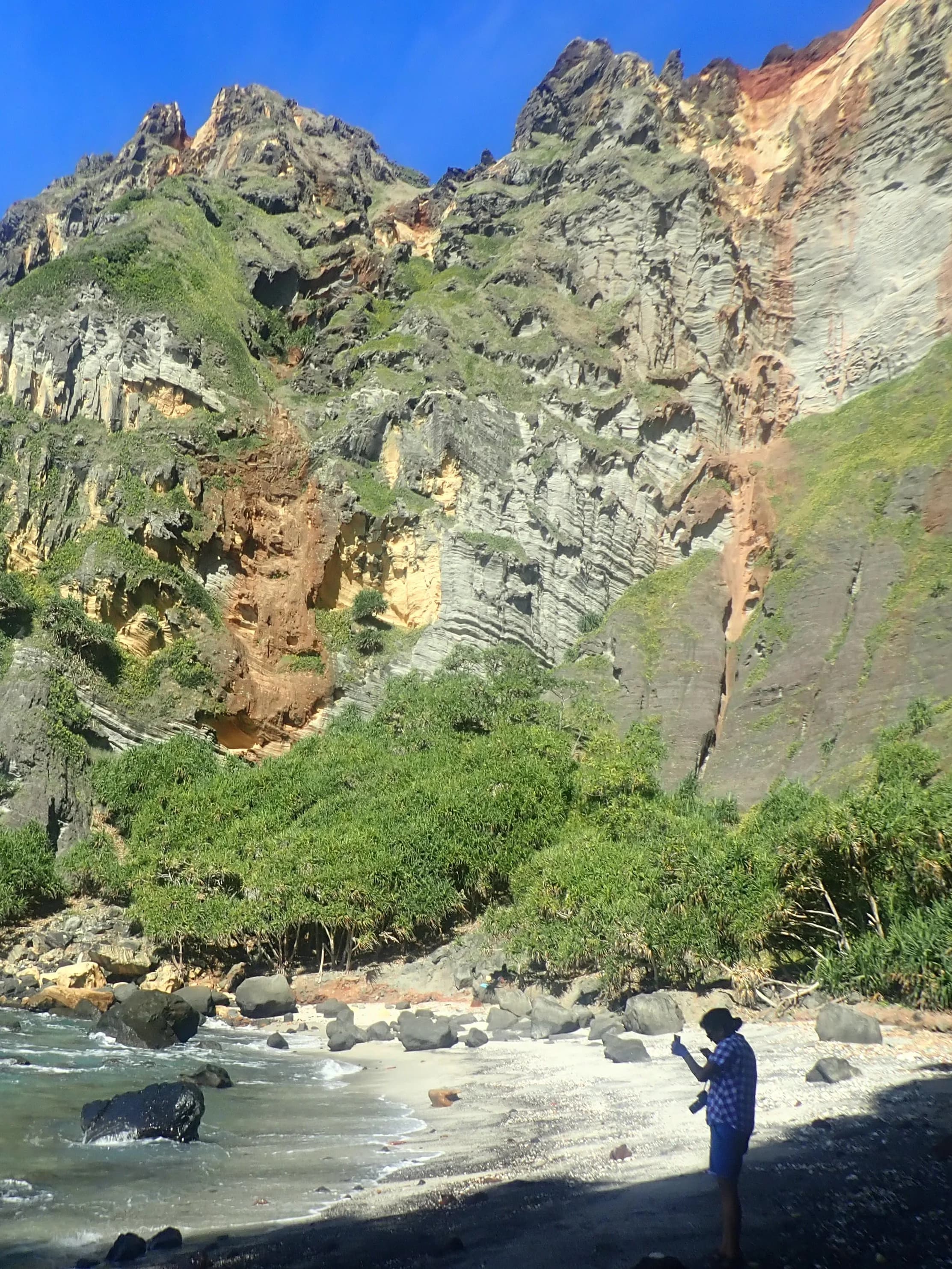 Down Rope, a cove of sand and rock below steep coloured cliffs