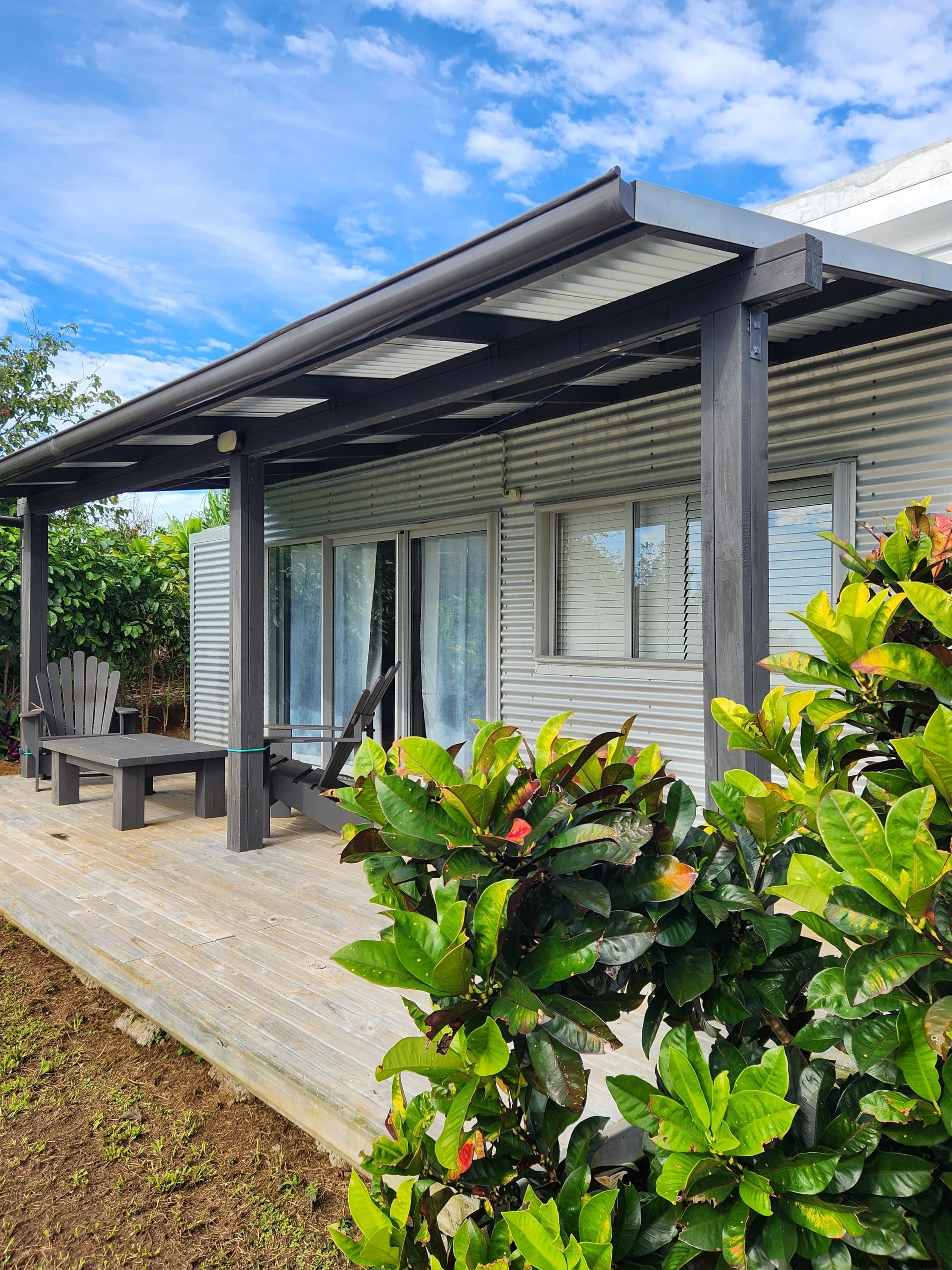 Little Flower, a standalone studio with a covered deck, among flowering shrubs